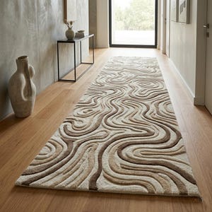 May include: A long rectangular runner rug featuring a raised, textured pattern of flowing, organic wavy lines in shades of cream, beige, and dark brown. The design creates a three-dimensional effect across the surface of the floor covering.