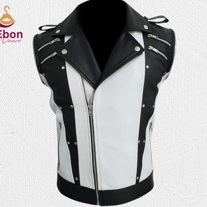 Peut inclure: Un gilet sans manches en cuir noir et blanc avec un col crant&eacute; et une fermeture &eacute;clair sur le devant. Le gilet comporte plusieurs fermetures &eacute;clair argent&eacute;es et des clous argent&eacute;s. Le gilet est con&ccedil;u avec un motif de blocs de couleurs.
