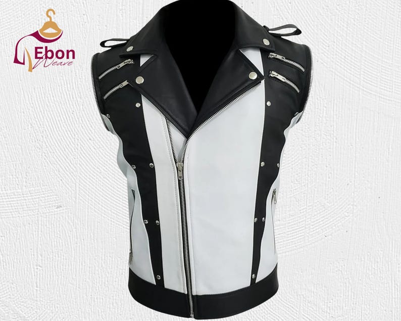 Peut inclure: Un gilet sans manches en cuir noir et blanc avec un col crant&eacute; et une fermeture &eacute;clair sur le devant. Le gilet comporte plusieurs fermetures &eacute;clair argent&eacute;es et des clous argent&eacute;s. Le gilet est con&ccedil;u avec un motif de blocs de couleurs.