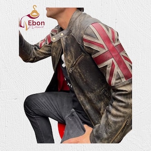May include: A distressed brown leather jacket with a Union Jack flag design on the shoulders. The jacket has a zipper closure, multiple pockets, and a worn appearance. The jacket is a classic style.
