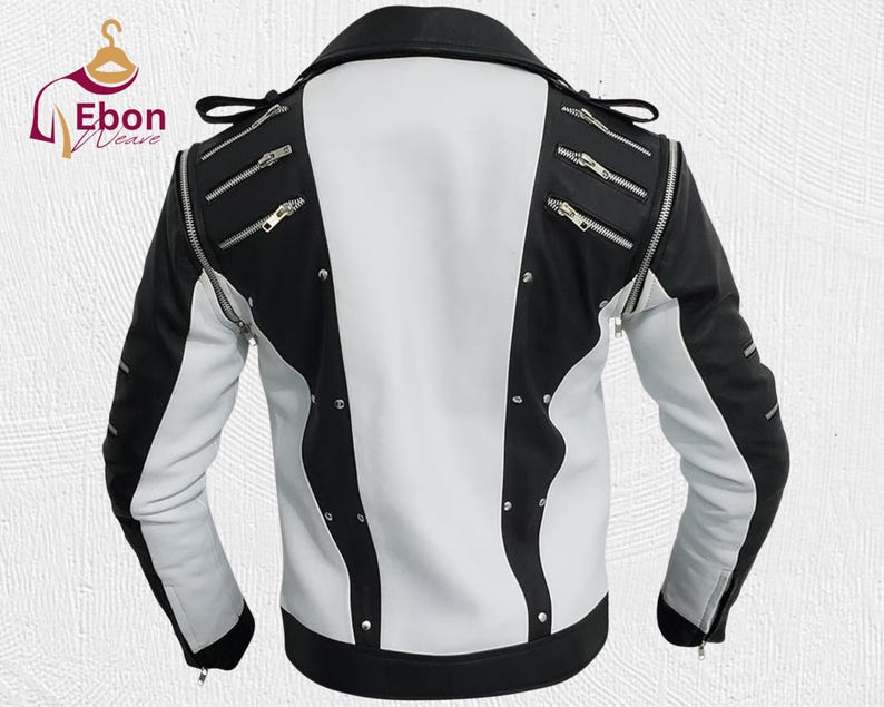 Peut inclure: Veste en cuir noire et blanche. Le dos et le devant sont blancs, tandis que les manches et les d&eacute;tails sont noirs. La veste est orn&eacute;e de fermetures &eacute;clair et de clous argent&eacute;s, pour un style motard classique.