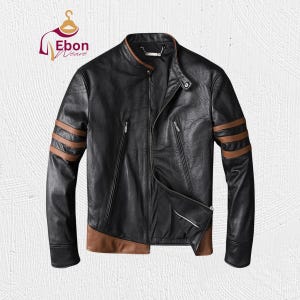 May include: Black leather jacket with brown detailing on the collar, sleeves, and hem. It has a zip-up front, two zipped pockets, and brown stripes on the sleeves. The jacket is designed in a classic biker style.