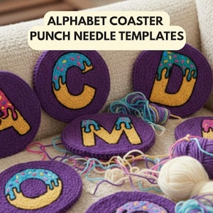 May include: Alphabet coaster punch needle templates. Circular purple coasters featuring letters with donut designs. The letters are A, C, D, M, and O. Yarn and thread are scattered around the coasters.