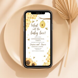 May include: A smartphone displays a baby gender reveal party invitation. The design features a honeycomb pattern, bees, and sunflowers. The text reads "What will the baby bee?" and includes the names Jessica and Aaron, along with the date and time.