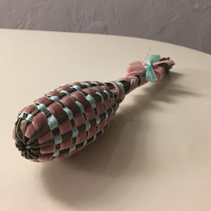 以下が含まれることがあります： 装飾用のラベンダーワンドが表示されています。ワンドはピンクのベルベットと水色のリボンで織られており、ストライプ模様になっています。ピンクのリボンと水色のリボンが上部を飾っています。白い表面にあります。