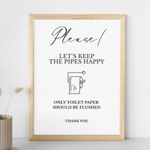 Op de afbeelding: Een ingelijste print met een licht houten frame. De witte achtergrond heeft zwarte tekst met "Please!" en "LET'S KEEP THE PIPES HAPPY." Hieronder staat een lijntekening van een toiletpapierrol. De tekst "ONLY TOILET PAPER SHOULD BE FLUSHED" staat eronder.