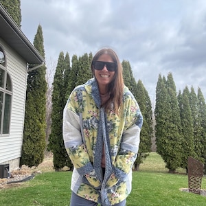 May include: A set of three ceramic mugs with a speckled, matte finish. The mugs are in shades of cream, light gray, and dark gray. Each mug has a simple, minimalist design and a rounded handle.