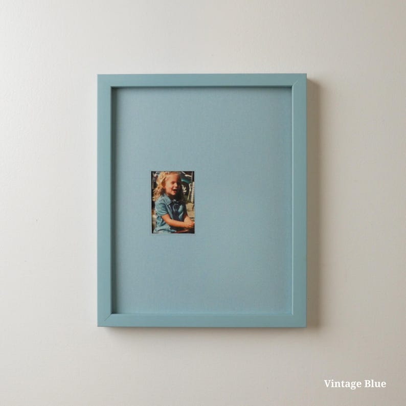 Pode incluir: Uma moldura quadrada azul vintage com uma pequena fotografia de uma crian&ccedil;a. A moldura &eacute; de cor azul clara lisa. O texto "Vintage Blue" est&aacute; no canto inferior direito.