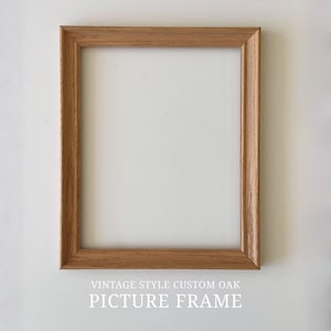 Puede incluir: Un marco de fotos rectangular de roble marr&oacute;n claro. El marco tiene un dise&ntilde;o cl&aacute;sico con una textura de veta de madera visible. El texto "VINTAGE STYLE CUSTOM OAK PICTURE FRAME" est&aacute; impreso en la parte inferior de la imagen.