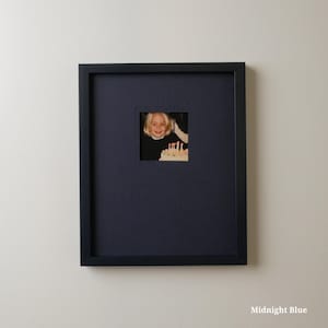 Pode incluir: Uma moldura quadrada azul meia-noite com uma abertura quadrada menor. Dentro da abertura est&aacute; uma fotografia de uma crian&ccedil;a sorrindo para um bolo de anivers&aacute;rio. A moldura est&aacute; pendurada em uma parede branca. O texto "Midnight Blue" est&aacute; na parte inferior.
