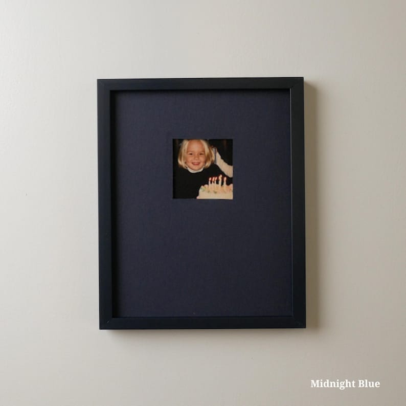 Pode incluir: Uma moldura quadrada azul meia-noite com uma abertura quadrada menor. Dentro da abertura est&aacute; uma fotografia de uma crian&ccedil;a sorrindo para um bolo de anivers&aacute;rio. A moldura est&aacute; pendurada em uma parede branca. O texto "Midnight Blue" est&aacute; na parte inferior.