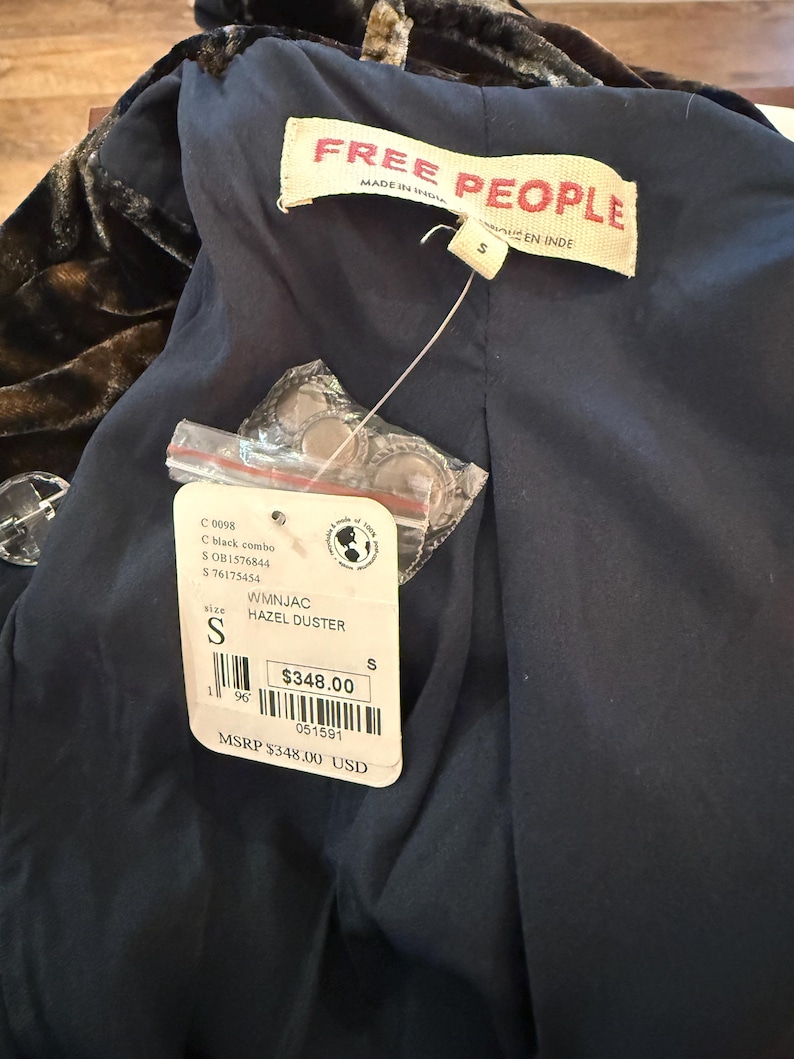 May include: A black and brown velvet duster coat with a navy blue lining. The tag reads "FREE PEOPLE" and "HAZEL DUSTER". The size is small. The tag also includes the text "MADE IN INDIA".