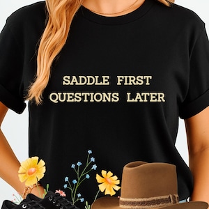 Saddle First Questions Later Shirt | Unisex Western Graphic Tee | Funny Horse Lovers Gift | Horselover Gift