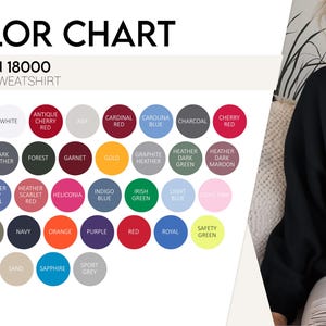 May include: A color chart for Gildan 18000 unisex sweatshirts featuring a grid of circular color swatches labeled with names like black, white, cherry red, gold, and safety green. A person wears a solid black crewneck sweatshirt on the right side.