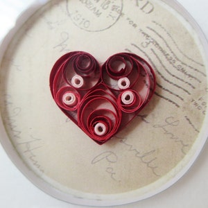 Coeur quilled de main avec le fond de carte postale