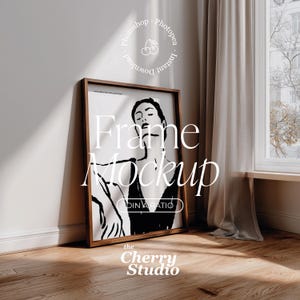 Puede incluir: Una maqueta de impresión artística enmarcada apoyada contra una pared blanca, con una ventana y cortinas en el fondo. La impresión presenta una ilustración en blanco y negro de una mujer. El marco es marrón y el texto "Frame Mockup" está visible.