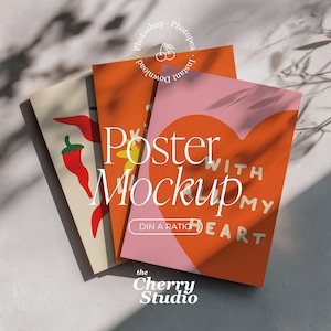 Puede incluir: Tres carteles con diseños coloridos. Uno presenta chiles rojos, otro tiene un diseño de corazón con las palabras "WITH ALL MY HEART", y el tercero las palabras "Poster Mockup". El logotipo de The Cherry Studio está en la parte inferior.