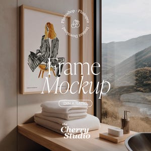 Puede incluir: Una impresión artística enmarcada con una ilustración de moda de una mujer con un atuendo a rayas en blanco y negro. El marco es de madera clara. Debajo, toallas blancas dobladas. Se muestra el texto "Frame Mockup".