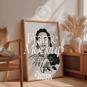 Puede incluir: Maqueta de impresión artística enmarcada con una ilustración en blanco y negro del rostro de una mujer. El marco es de color marrón claro. El texto "Frame Mockup" se muestra en la obra de arte. El logotipo de The Cherry Studio es visible en la parte inferior.