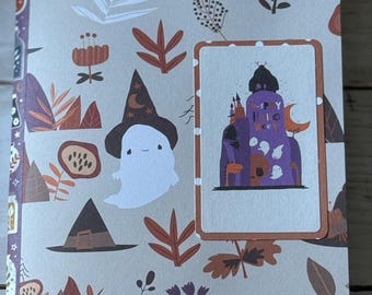 May include: A Halloween-themed card with a beige background featuring botanical illustrations in brown and orange. The card includes a rectangular image with a cartoon ghost wearing a witch hat and a purple castle with the text "Happy Hallo".