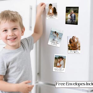 May include: A young child smiles while placing a magnet on a white refrigerator. The magnets are rectangular and feature photos of couples, with text that reads "Save the Date" and names and dates. The bottom of the refrigerator has a text box that reads "Free Envelopes Included."