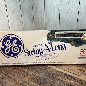 May include: A vintage box of General Electric miniature String-A-Long light set with 50 solid color bulbs. The box features the GE logo and text that reads "Indoor/Outdoor". The box is white with blue and green accents.