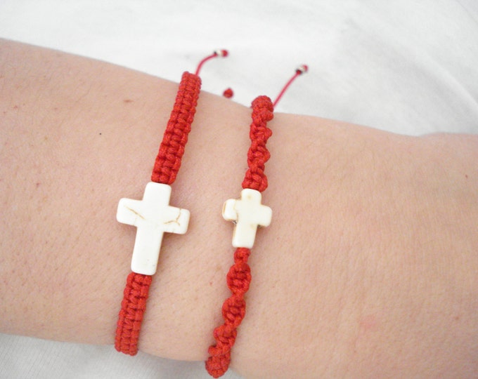 White howlite cross in a red string bracelet