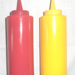May include: Two plastic condiment bottles, one red and one yellow. The bottles have a pointed top and a wide base.