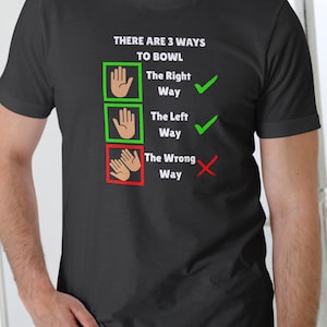 May include: Black t-shirt with white text: "THERE ARE 3 WAYS TO BOWL." The shirt features hand illustrations in green and red boxes, with check marks and an X, indicating the right, left, and wrong ways to bowl.