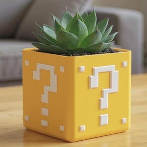 Peut inclure: Un pot de plante carré jaune avec des motifs de points d'interrogation blancs, contenant une plante succulente verte. Le pot est posé sur une table en bois. Un canapé gris et une fenêtre sont en arrière-plan.