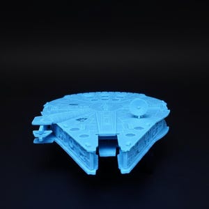 Peut inclure: Modèle imprimé en 3D, bleu clair, du vaisseau spatial Millennium Falcon. Le modèle présente des panneaux détaillés, un radar circulaire et le design emblématique du cockpit. Ce vaisseau spatial est un objet populaire de la franchise Star Wars.