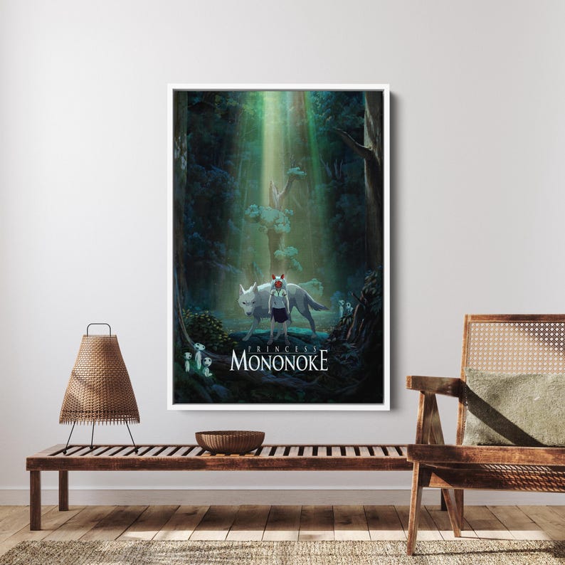 May include: A framed art print featuring a scene from "Princess Mononoke." The artwork depicts a young figure with a wolf in a forest setting, with the title text at the bottom. The color palette includes greens, blues, and whites.