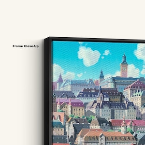 May include: Close-up of a framed canvas print featuring a colorful illustration of a European townscape. The artwork depicts buildings with red, purple, and brown roofs under a blue sky with white clouds. The frame is black, and the text "Frame Close-Up" is visible.