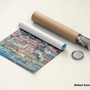 May include: Rolled canvas poster featuring a colorful cityscape with buildings and a river. The poster is partially unrolled, revealing the artwork. A white tube, a brown tube, and a silver cap are also present.