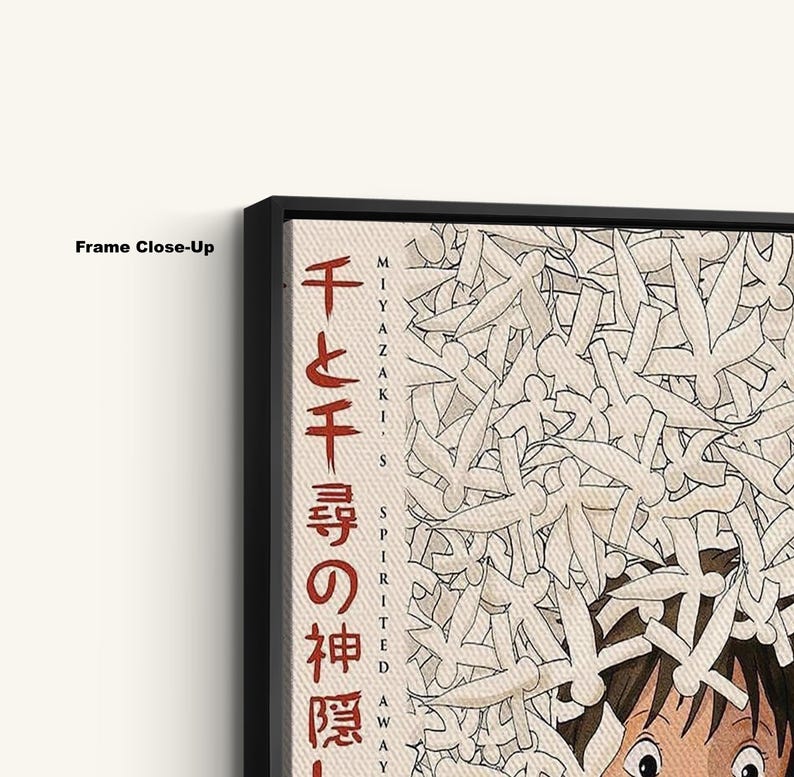 May include: Close-up of a framed print featuring Japanese text and artwork. The print has a black frame and displays a beige background with white and black illustrations. The Japanese text is in red and black.