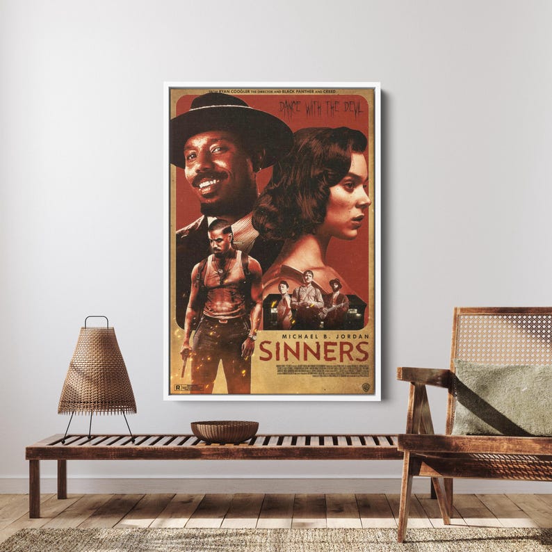 May include: A framed movie poster with a white border. The poster features actors and the title "Sinners" in a vintage style. The color palette is dominated by shades of red, brown, and black. The poster is displayed on a wooden bench.