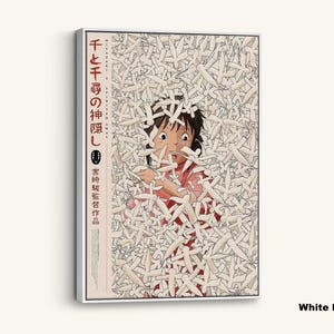 May include: White framed canvas art featuring a scene from the animated film "Spirited Away." The artwork depicts a young girl surrounded by white paper-like figures. Japanese text is visible on the left side of the canvas.