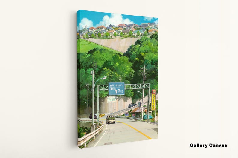 May include: Canvas art print of a road scene with a blue sky and a town in the background. The artwork features a road with a yellow center line, green trees, and a sign with Japanese text. The canvas is mounted on a white wall.