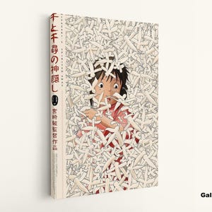 May include: A canvas print of the animated film "Spirited Away." The artwork features a central image of a character surrounded by white figures. Japanese text is visible on the side of the canvas.