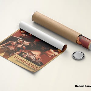 May include: A rolled canvas poster with a movie poster design, featuring the word "Sinners" and images of people. The poster is partially unrolled, next to a white tube and a brown cardboard tube. A silver cap is also present.