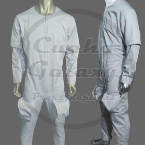 May include: A light grey jumpsuit with a zip-up front, short sleeves, and large pockets on the thighs. The costume is displayed on a mannequin. The jumpsuit has a white collar and is made of a soft material.