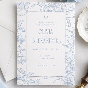 Pode incluir: Um conjunto de convites de casamento com um design floral azul claro sobre branco. O convite inclui os nomes "Olivia e Alexander" e a data "20 de agosto". Um envelope branco, um selo e um selo de cera também são visíveis.