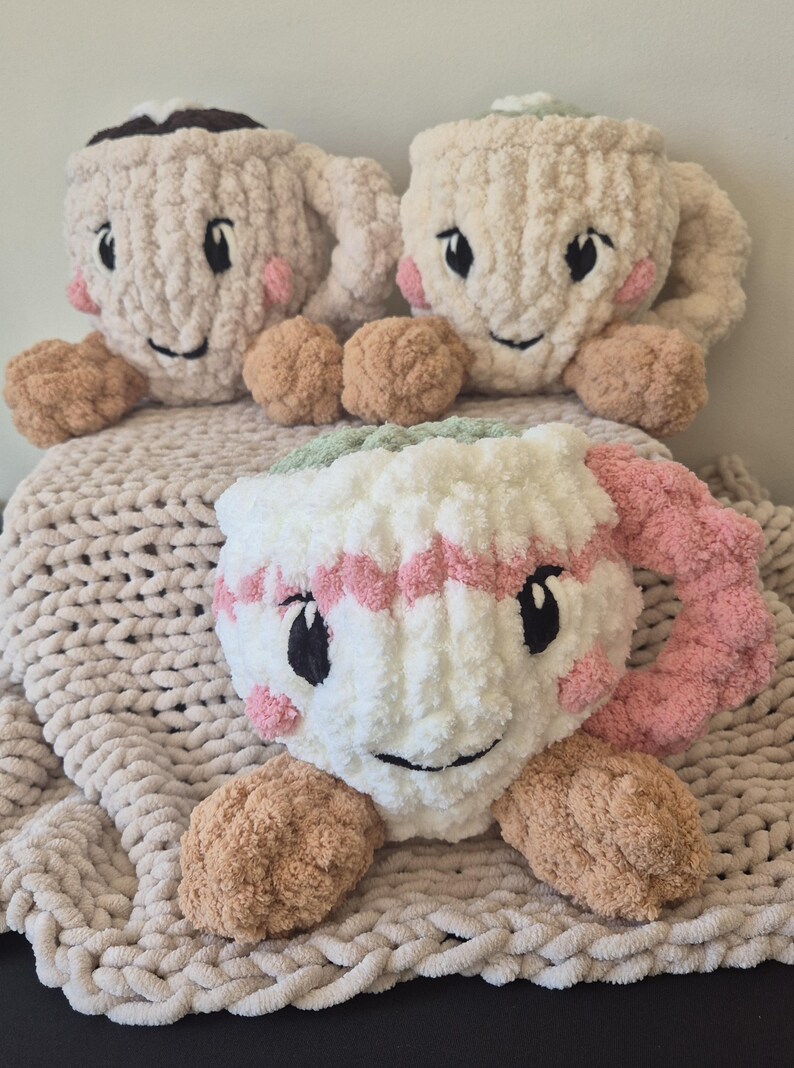 Pu&ograve; includere: Tre peluche a forma di tazza realizzati in morbido filato spesso. Due tazze sono color crema con la parte superiore marrone, mentre la terza &egrave; bianca con strisce rosa e la parte superiore verde. Ogni tazza presenta occhi neri ricamati e guance rosa.