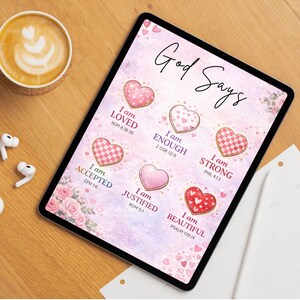 May include: A tablet screen displaying a pink graphic with the text God Says and six heart illustrations. Each heart is paired with a phrase: I am LOVED, I am ENOUGH, I am STRONG, I am ACCEPTED, I am JUSTIFIED, and I am BEAUTIFUL, with Bible verses.