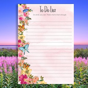 May include: A pink To Do List notepad with floral and butterfly accents. The notepad features a watercolor design with a floral border and butterflies in shades of blue and orange. The text "To Do List" is at the top.