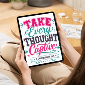 Op de afbeelding: Een digitale tablet met een grafisch ontwerp met de tekst "TAKE EVERY THOUGHT CAPTIVE" in vetgedrukte roze, groenblauwe en donkergrijze letters, vergezeld van decoratieve pijlen, hartjes en het citaat "2 CORINTHIANS 10:5" op een banner.