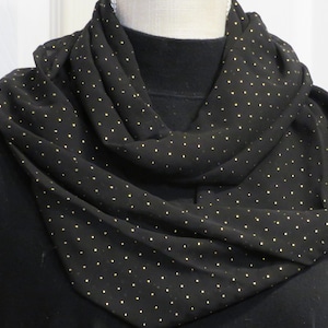 May include: A black infinity scarf with gold polka dots. The scarf is made of a soft, sheer fabric.