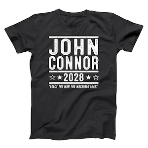 May include: Black t-shirt with white text that reads "JOHN CONNOR 2028" with star accents. Below the text is the quote, "ELECT THE MAN THE MACHINES FEAR."