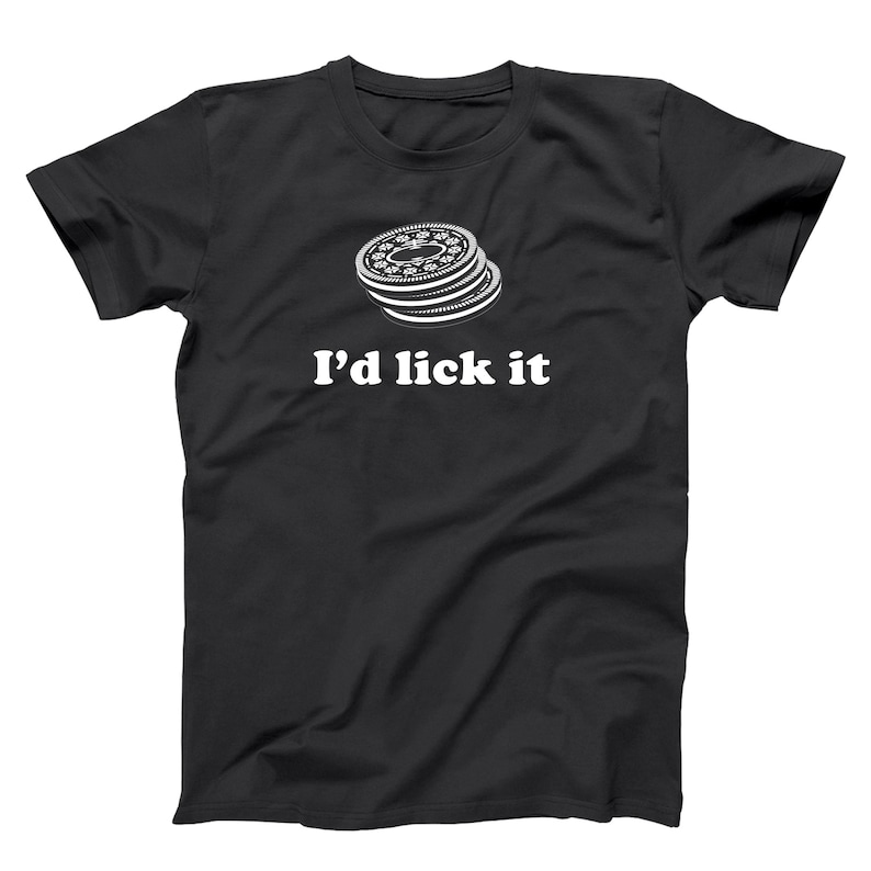 May include: Black t-shirt with a white graphic of stacked cookies and the text "I'd lick it". The cookies have a detailed design. The shirt is a classic crew neck style.