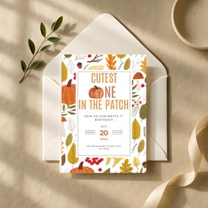 May include: A fall-themed invitation card with the text "Cutest One in the Patch" and a pumpkin illustration. The card is surrounded by autumn leaves and pumpkins. The invitation is inside a white envelope.